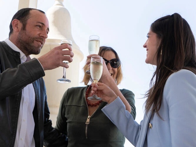 An advisor and her clients raise a glass of champagne after a signing